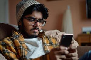 Young man using a smartphone at home photo