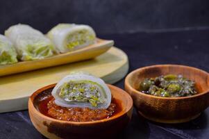 Sawi gulung tahu or rolled Chinese cabbage with tofu. Served with red chilli sauce and green chilli sauce. photo