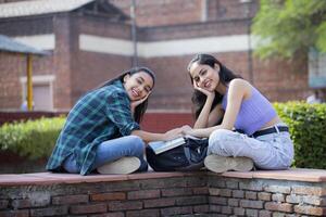 Two Innocent Friends Looking At the Camera With Both Hands Under Their Chin photo