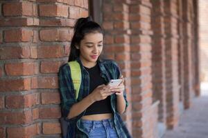 A Young Female Stands Up and is Typing On Her Phone photo