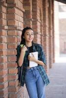 Appealing Woman Standing On a College Campus With Books in Her Hand photo