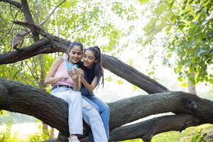 Two Females Smiling While Using Their Phones photo