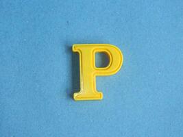 Macro photo or closeup photo of the alphabet from children's toys on a blue background. Use on preschool also