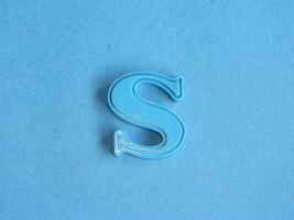 Macro photo or closeup photo of the alphabet from children's toys on a blue background. Use on preschool also