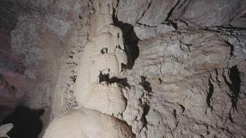 Underground cave formations of stalactites and stalagmites. Action. View inside of a cavern on giant stone walls. video