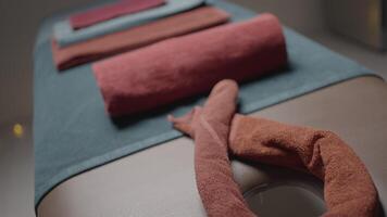 Close-up of place with massage towels. Action. Towels on massage table before procedure. Preparation of massage place with folded towels video