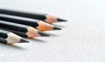 Graphite pencils lying on a blank sheet of white paper photo