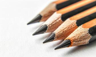 Graphite pencils lying on a blank sheet of white paper photo
