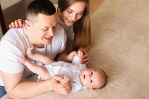 parents play with a baby at home on a bed covered with a linen bedspread. family concept. happy parenthood concept. photo