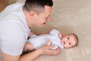 close-up dad plays with a small child at home on the bed. parent hugging a small child. family concept photo