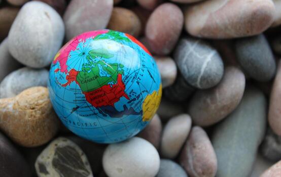 Miniature Globe With A Visible Image Of The USA and Canada On Small Round Sea Rocks photo