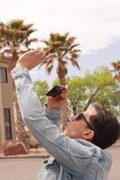Young Man Looking at the Sun and taking photos During a Solar Eclipse using a Black Obsidian Stone