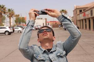 Young Man Looking at the Sun and taking photos During a Solar Eclipse using a Black Obsidian Stone