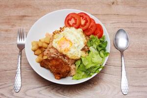 Fried rice with tomato sauce Or as we call it American fried rice Served with fried eggs, fried chicken, fresh stir-fry, and fried bread. photo
