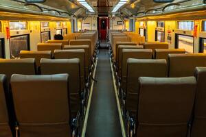 Public trains in Java, Indonesia are empty of passengers in the afternoon when the sun sets. The train carriage was quiet and many passenger seats were empty photo