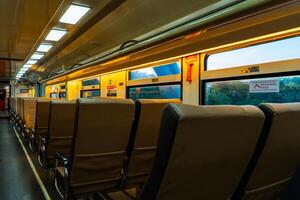 Public trains in Java, Indonesia are empty of passengers in the afternoon when the sun sets. The train carriage was quiet and many passenger seats were empty photo