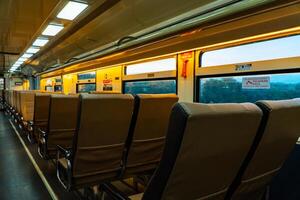 Public trains in Java, Indonesia are empty of passengers in the afternoon when the sun sets. The train carriage was quiet and many passenger seats were empty photo