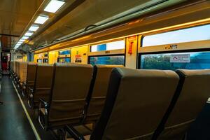 Public trains in Java, Indonesia are empty of passengers in the afternoon when the sun sets. The train carriage was quiet and many passenger seats were empty photo