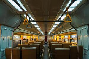 Public trains in Java, Indonesia are empty of passengers in the afternoon when the sun sets. The train carriage was quiet and many passenger seats were empty photo