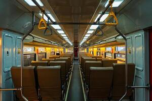 Public trains in Java, Indonesia are empty of passengers in the afternoon when the sun sets. The train carriage was quiet and many passenger seats were empty photo
