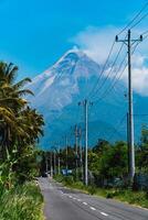 Mount Merapi in Indonesia in the afternoon is very clear and majestic from a distance. Panorama of mountains with a blue sky background on a sunny day photo