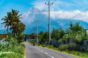 Mount Merapi in Indonesia in the afternoon is very clear and majestic from a distance. Panorama of mountains with a blue sky background on a sunny day photo