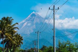 Mount Merapi in Indonesia in the afternoon is very clear and majestic from a distance. Panorama of mountains with a blue sky background on a sunny day photo