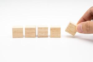 Hand place wooden cube blocks arranged in a row isolated on white background. Blank wooden blocks for text. Copy space. photo