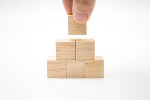 Hand putting and stacking blank wooden cubes on white background with copy space for input wording and infographic icon. photo