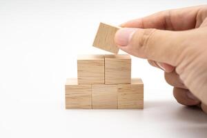 Hand putting and stacking blank wooden cubes on white background with copy space for input wording and infographic icon. photo