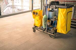 Cleaning tools cart in public walk way. Bucket and set of cleaning equipment. Concept of service, worker and equipment for cleaner and health. photo
