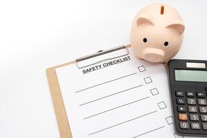 Blank Safety checklist with Calculator and Piggy Bank. safety for Business. Empty safety checklist form on white background. saving money for protection, planning in future. photo