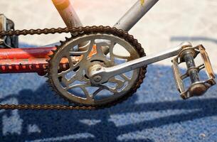 The old chains and pedals of antique tricycles that have been sitting there for so long are rusting. photo
