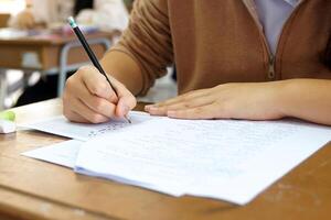 Asian students are taking exams to measure learning in the classroom. Soft and selective focus. photo
