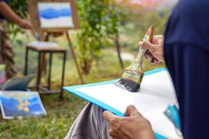 The students used paint brushes to color the distant mountain ranges from light blue to dark blue. Follow the example the teacher gives you. soft and selective focus. photo