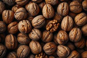 A pile of brown walnuts, nuts background top view photo