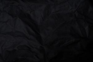 Black crumpled paper with shadow for background. wrinkled surface, design, wallpape photo