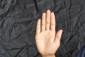 The man's hands are making a prohibition or stop gesture. photo