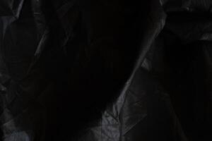 Black crumpled paper with shadow for background. wrinkled surface, design, wallpape photo
