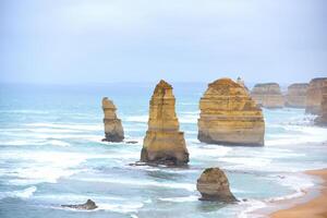 View of the 12 Apostles in cloudy day, Erosion of the mainland coast's limestone cliffs on The Great Ocean Road is an Australian National Heritage-listed at south-eastern coast of Victoria, Australia photo