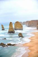 View of the 12 Apostles in cloudy day, Erosion of the mainland coast's limestone cliffs on The Great Ocean Road is an Australian National Heritage-listed at south-eastern coast of Victoria, Australia photo