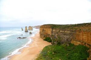 View of the 12 Apostles in cloudy day, Erosion of the mainland coast's limestone cliffs on The Great Ocean Road is an Australian National Heritage-listed at south-eastern coast of Victoria, Australia photo