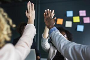 group of colleagues giving a high five in meeting. photo
