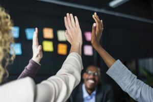 group of colleagues giving a high five in meeting. photo