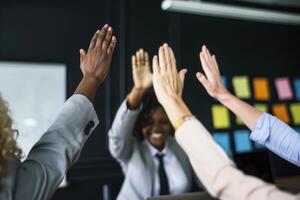 group of colleagues giving a high five in meeting. photo
