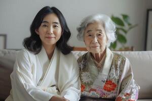 Japanese adult woman and her old mother sitting on the couch hugging. photo