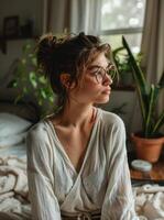 Unhappy woman thinking about problems, sitting in the bed alone looking away. photo