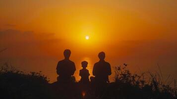 Silhouette of a family watching the sunset together, creating a warm and loving atmosphere photo