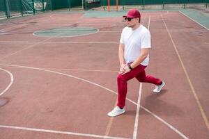 Athletic bearded man warms up before workout at the stadium photo