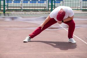 Athletic bearded man warms up before workout at the stadium photo